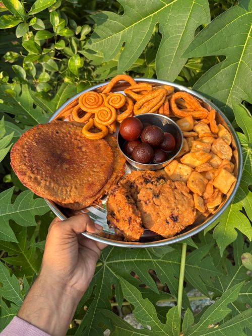 Free A vibrant assortment of Indian sweets and snacks displayed outdoors on a lush green leaf. Stock Photo