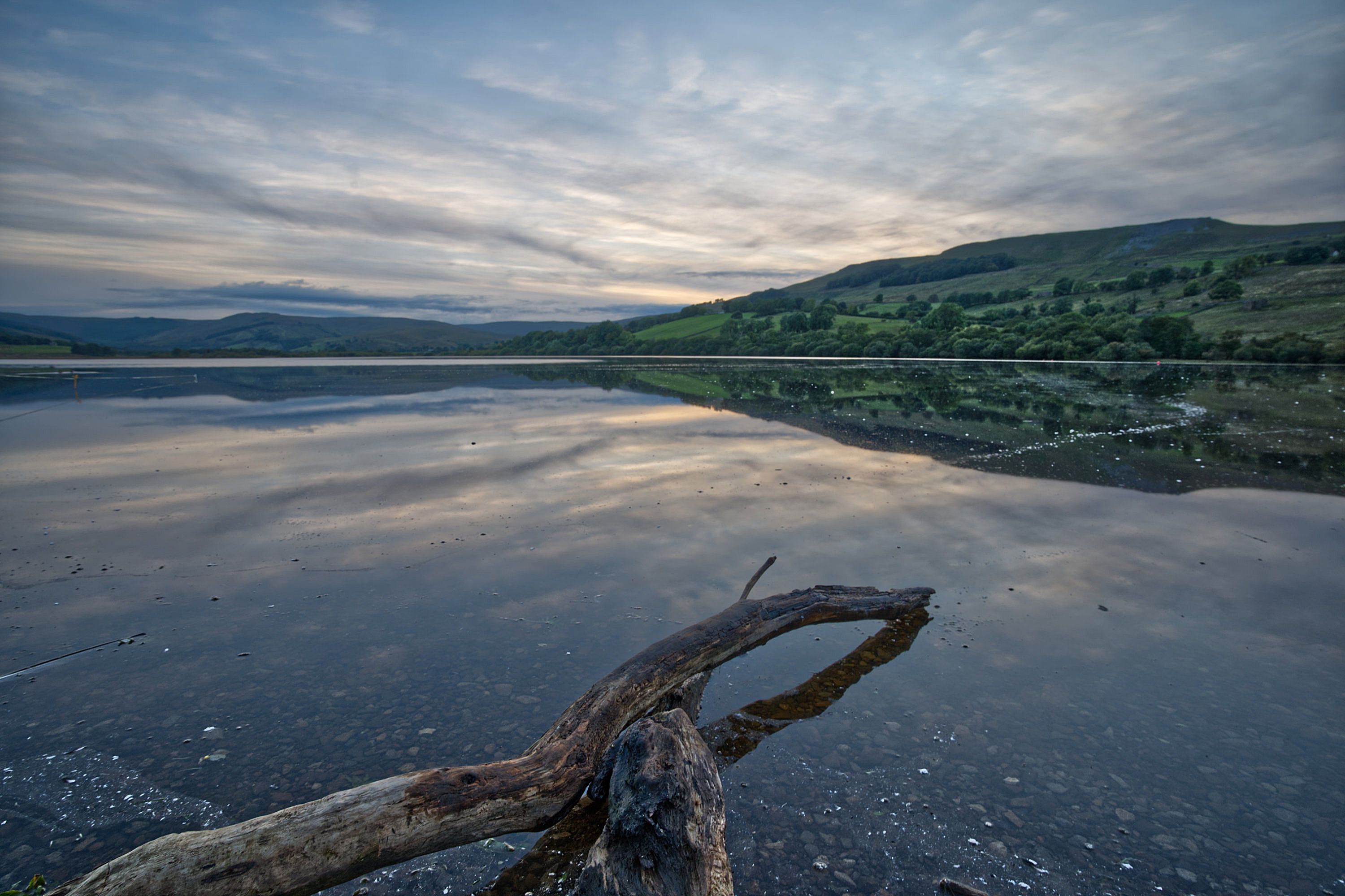 Tranquil lake scene with vivid sky reflections in England, captured at dusk.