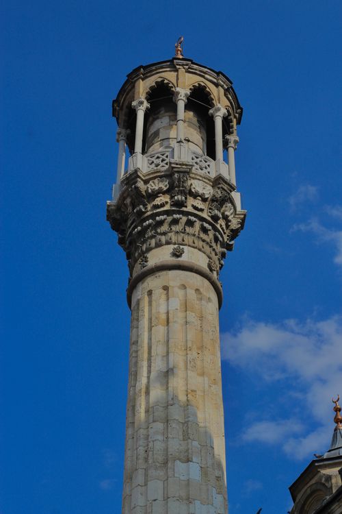 Free Close-up of a historic architectural tower with ornate details set against a clear blue sky. Stock Photo