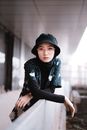 一幅现代城市环境中戴着水桶帽的时尚前卫女性肖像