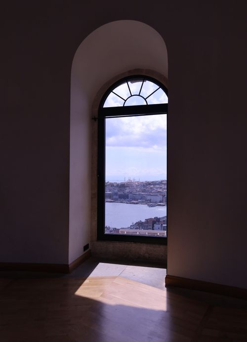 Free Beautiful view of a city skyline through an arched window, capturing the essence of urban life. Stock Photo
