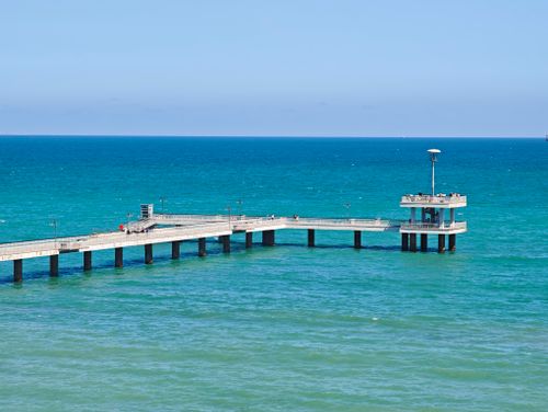 Free A picturesque view of the Varna Sea Bridge pier extending into turquoise waters under a clear blue sky. Stock Photo