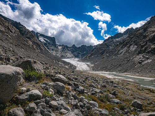 Free A breathtaking view of a rocky alpine valley and glacier under a dramatic sky in Bregaglia, Switzerland. Stock Photo