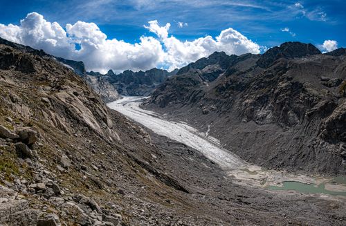Free Dramatic view of the Bregaglia Valley, showcasing the rugged mountain terrain and a majestic glacier under a vibrant blue sky. Stock Photo