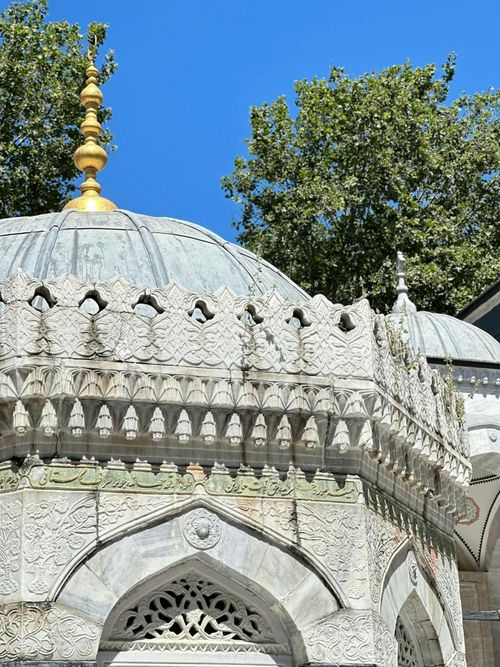 Free Close-up of an ornate mosque dome with intricate carvings and a clear blue sky. Stock Photo