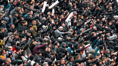 Free A large, animated crowd in stadium seating, expressing excitement and energy during a sports event. Stock Photo