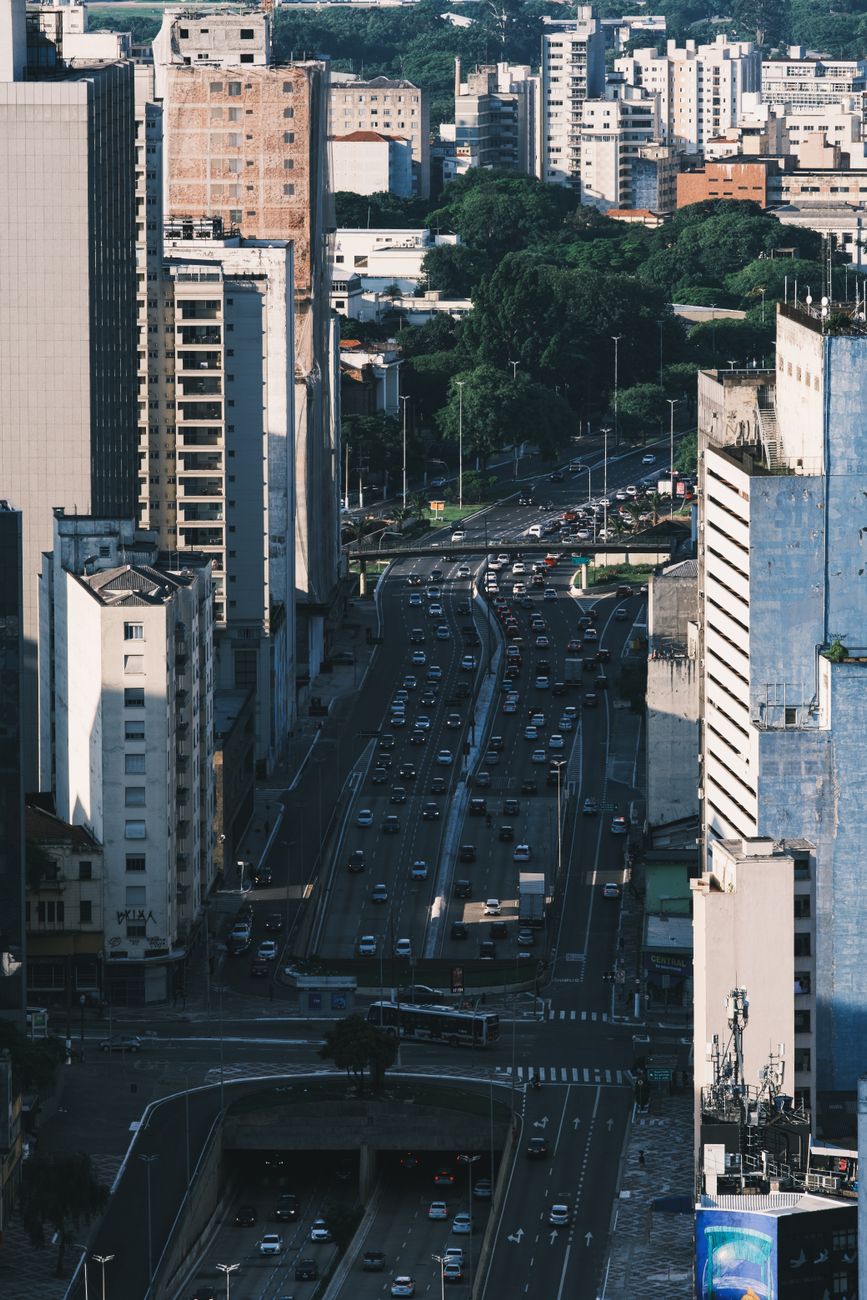 Aerial shot of a bustling city with heavy traffic and tall buildings, captured during the day.