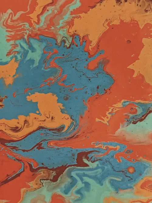 Free Dynamic abstract water marbling painting featuring vibrant swirls of blues and oranges. Stock Photo