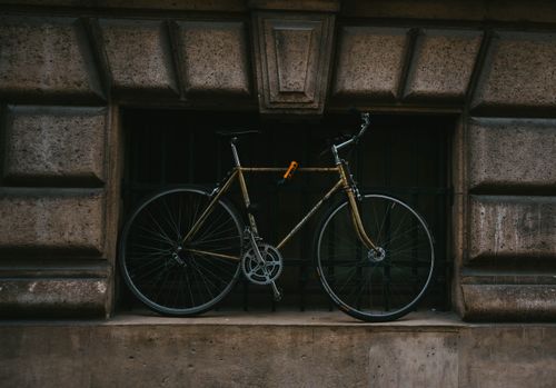 Free A stylish bicycle rests against a classic stone facade in the streets of Paris, France. Stock Photo