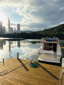 Scenic Itajaí River view at sunset featuring yacht and city skyline under dramatic clouds.