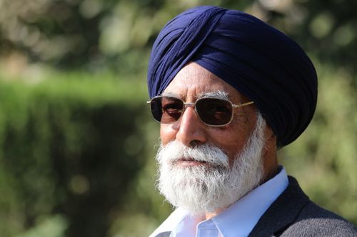 Free Portrait of an elderly man wearing a turban and glasses, enjoying a sunny day outdoors. Stock Photo