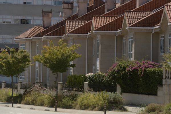 Rangée de maisons mitoyennes aux toits de tuiles rouges et aux bougainvilliers, en Espagne