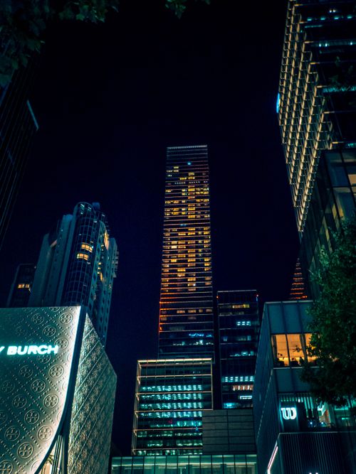 Free Dramatic view of illuminated skyscrapers against night sky in a bustling cityscape. Stock Photo