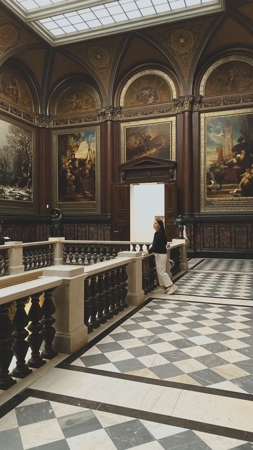 Free Elegant art museum interior in Hamburg, featuring classical paintings and a lone visitor admiring the gallery. Stock Photo