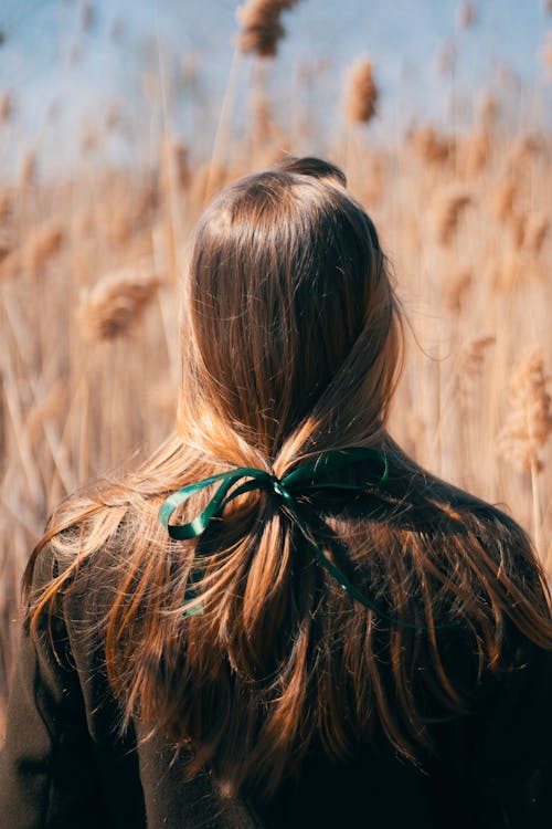 Женщина, стоящая на поле коричневой травы