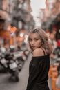 一位别致的女子自信地在繁华的街道上摆出姿势，将时尚与城市氛围融为一体