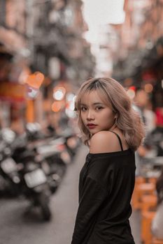 一位别致的女子自信地在繁华的街道上摆出姿势，将时尚与城市氛围融为一体