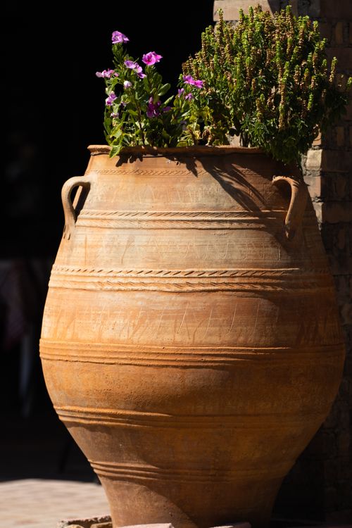 Free Large terracotta pot with vibrant flowers and herbs, sunlit, on a patio in Corfu, Greece. Stock Photo