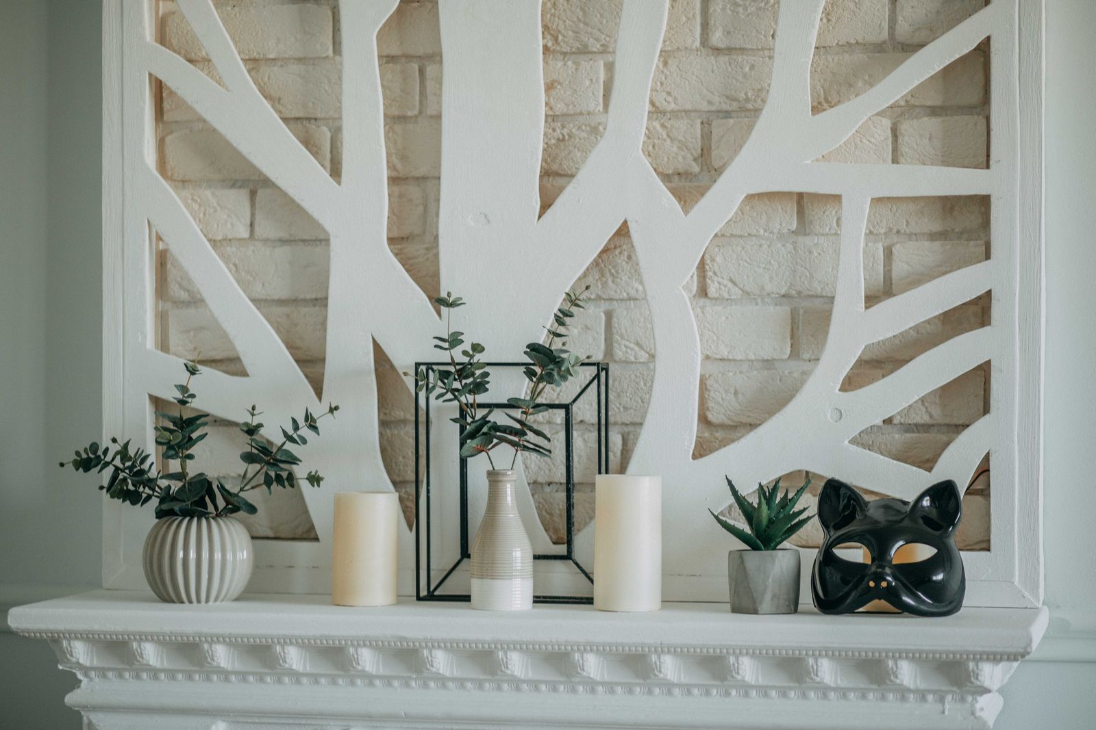 stylish mantel display with candles, vases, and plants, landscape