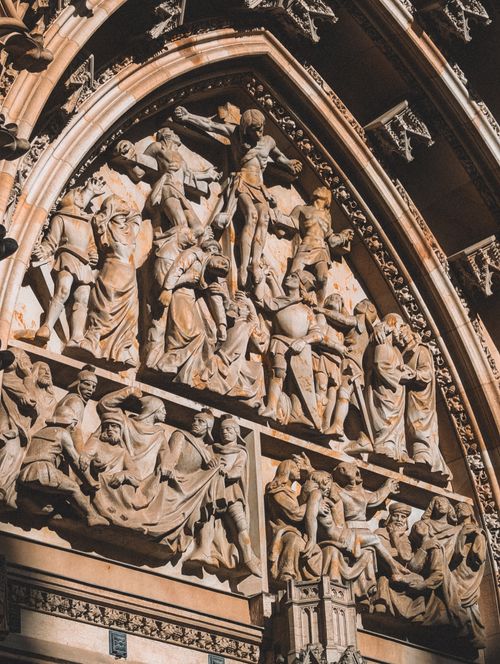 Free Intricate Gothic stone relief depicting historical scenes on a cathedral facade in Prague. Stock Photo