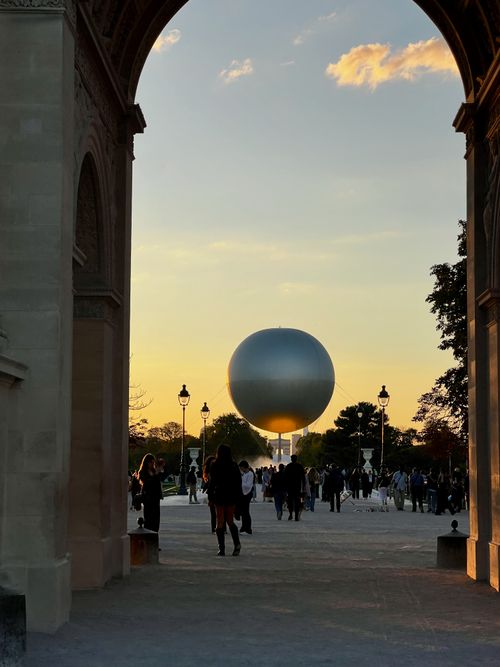 Free A stunning sunset scene with a spherical sculpture framed by architectural archways. Stock Photo