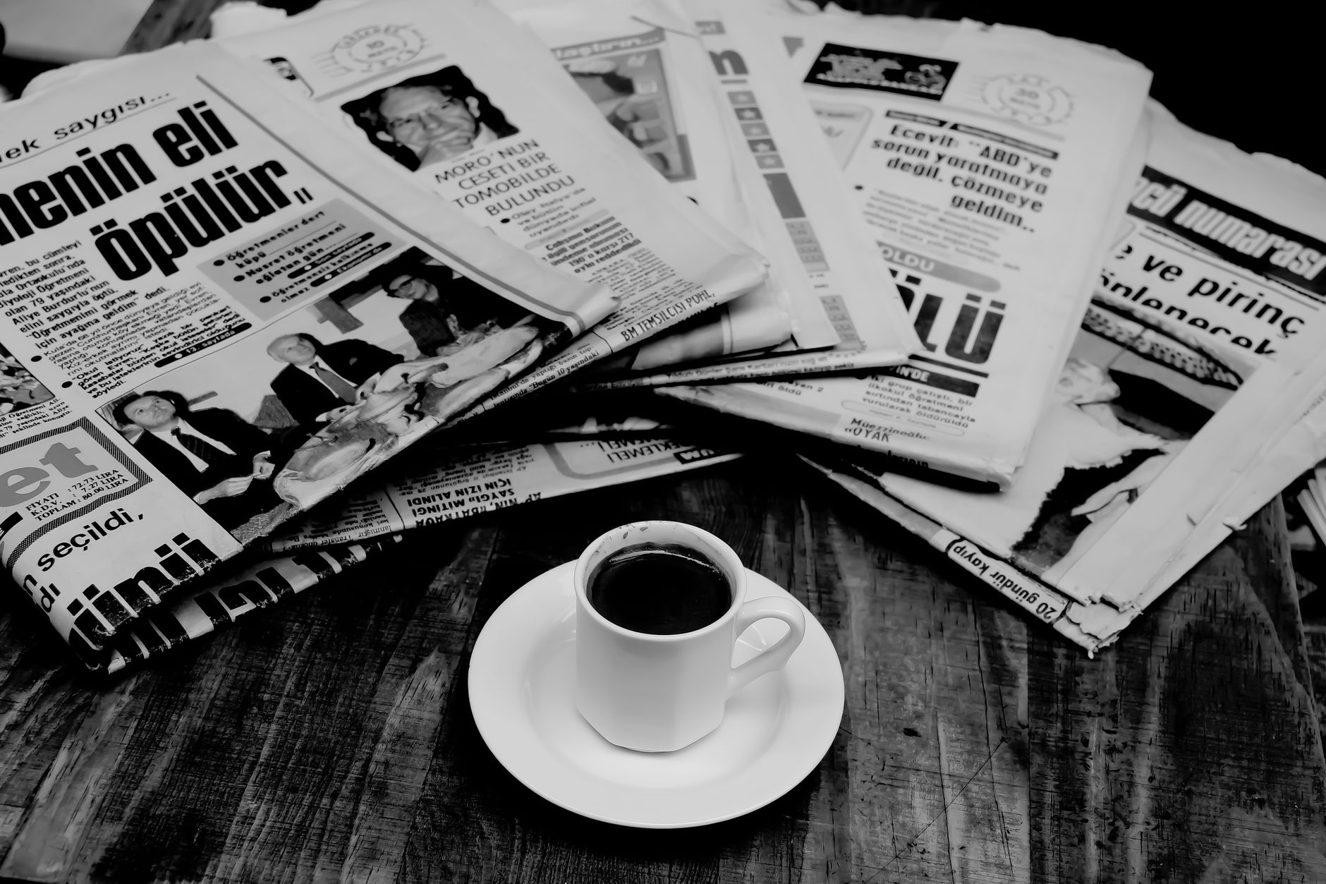 Nederlander op Spaans terras met koffie en telefoon, internationaal nieuws lezend in de ochtendzon.