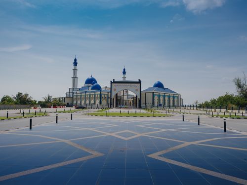 Free A beautiful mosque with blue domes and minarets under a clear sky in Malaysia. Stock Photo