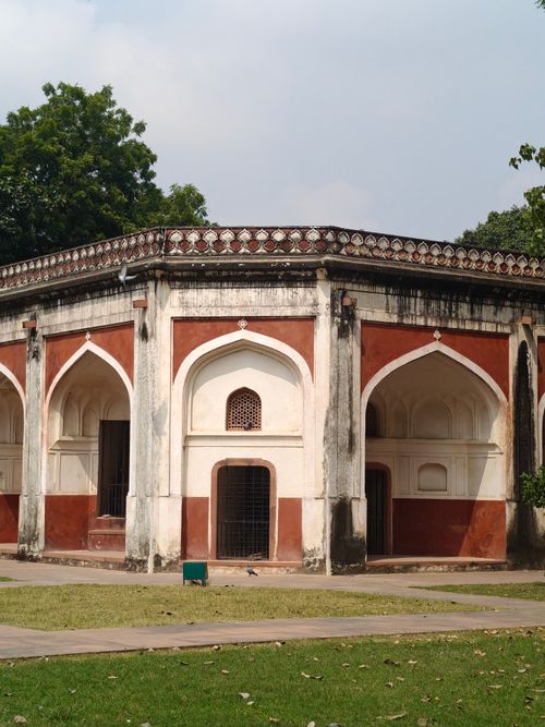 Free Historic red and white arched structure surrounded by lush greenery in New Delhi, India. Stock Photo