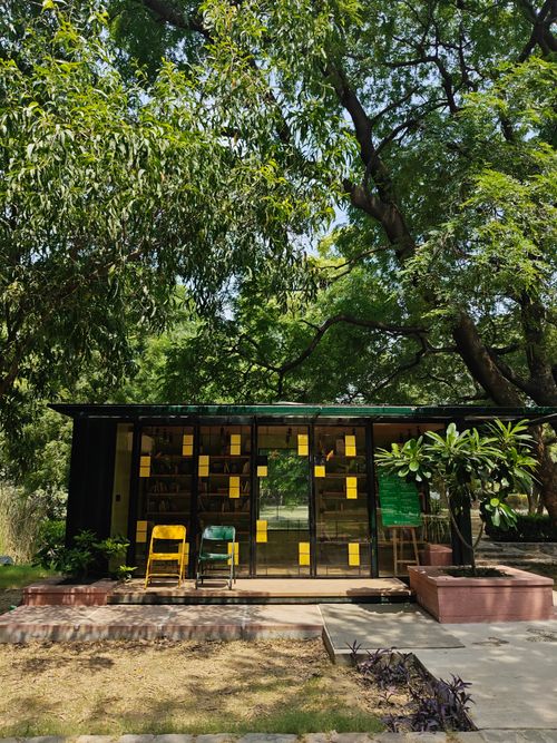 Free A cozy glass-front library in New Delhi's lush urban park captures serene reading moments. Stock Photo