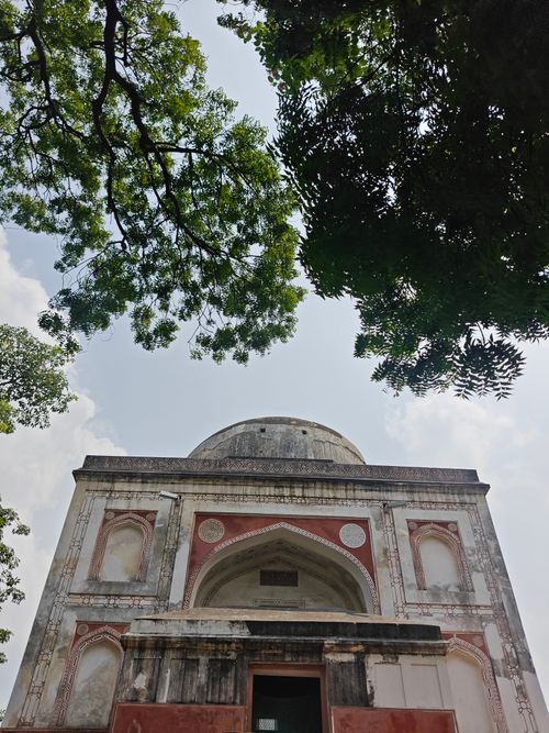 Free A historic tomb surrounded by green trees under a bright sky in New Delhi, India. Stock Photo