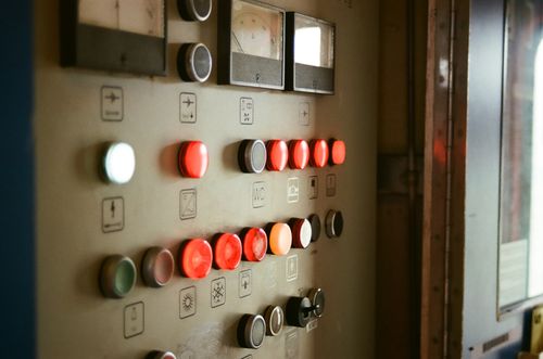 Free Close-up of a control panel with illuminated buttons and gauges, suggesting industrial technology. Stock Photo