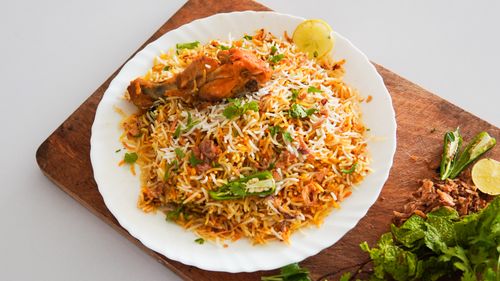 Free Mouth-watering chicken biryani served on a white plate with herbs and spices. Stock Photo