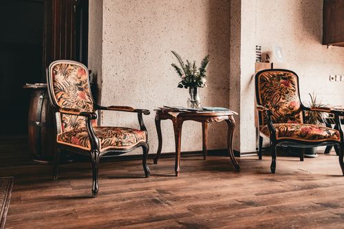 Free A cozy indoor space featuring vintage armchairs, ornate table, and floral decor. Ideal for classic style inspirations. Stock Photo