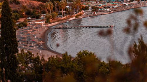 Free A serene beach with umbrellas and a pier at sunset, perfect for relaxation. Stock Photo