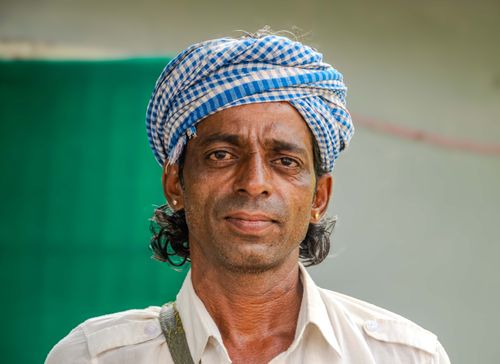 Free Close-up portrait of a man wearing a checkered turban and white shirt outdoors. Stock Photo