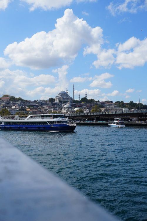Free Blue boats on the Bosphorus with Istanbul's skyline and a mosque under a blue sky. Stock Photo