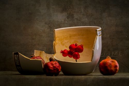 Free A creative arrangement of pomegranates and broken pottery, emphasizing balance and color. Stock Photo