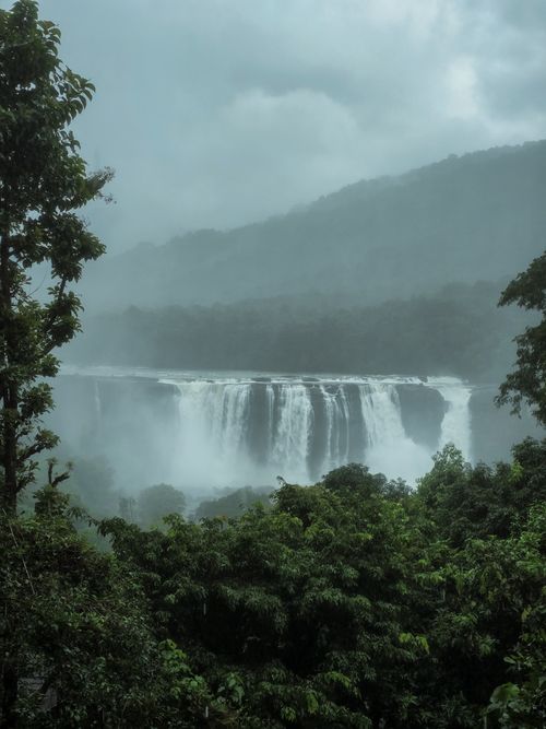 Free A breathtaking view of a waterfall cascading through a misty rainforest, showcasing nature's beauty. Stock Photo
