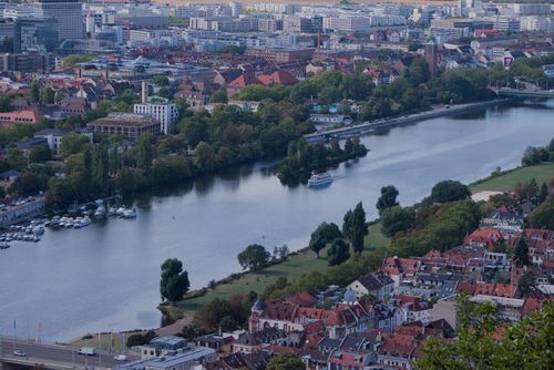 Free Beautiful aerial view of Frankfurt's urban landscape along the river Main, featuring lush greenery and vibrant architecture. Stock Photo