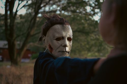 Free A chilling scene of a masked figure in a forest setting, evoking a horror movie atmosphere. Stock Photo