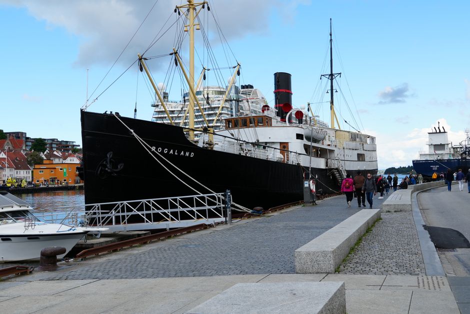 Steamboat Rogaland docked at Hamburg harbor, Germany, with tourists strolling along the quay.