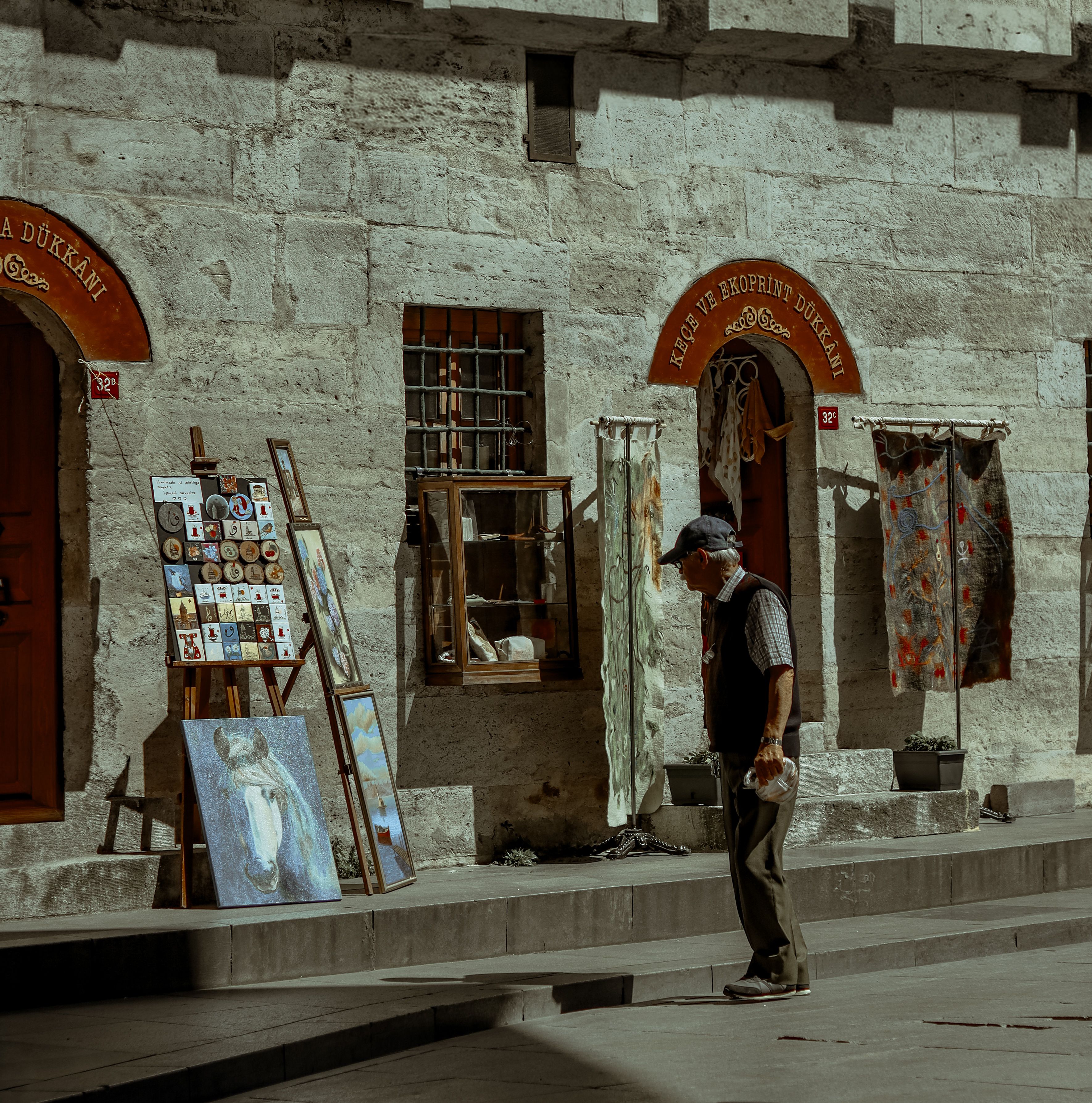 Man appreciates street art in İstanbul's historic district, capturing local culture.