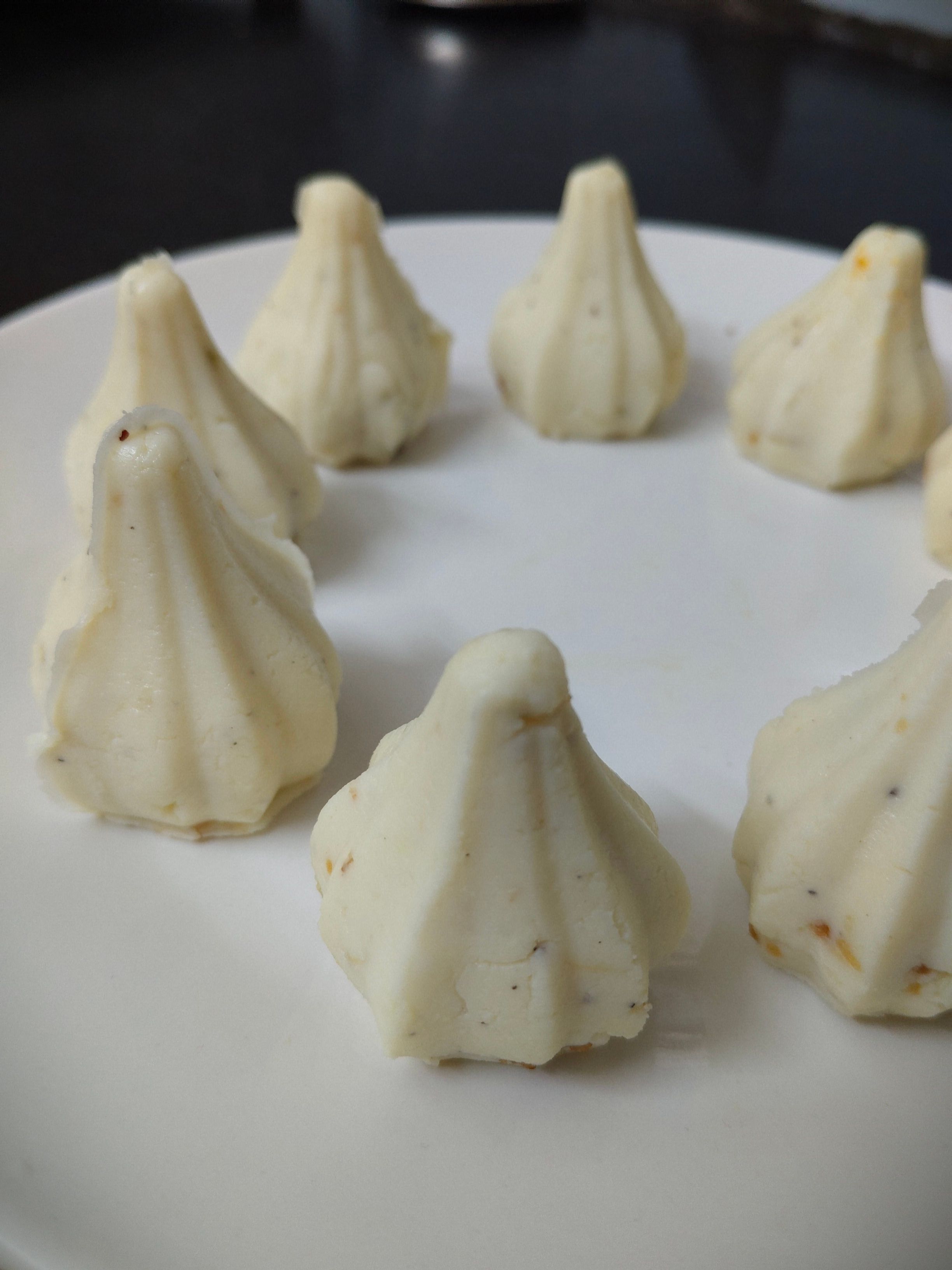 Delicious white modak sweets arranged on a plate, perfect for festivals.