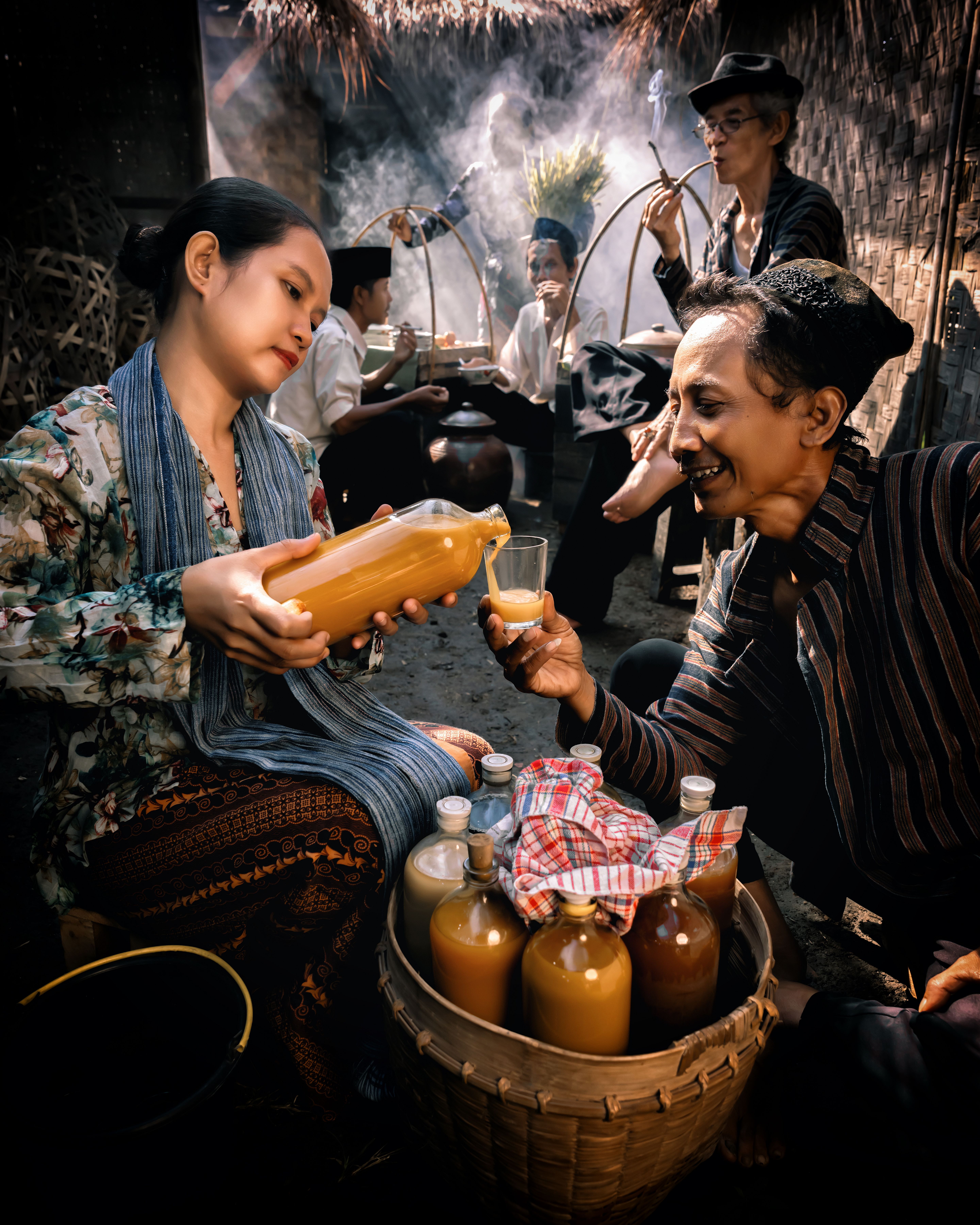 People enjoying traditional homemade beverage in a rustic, cultural setting.