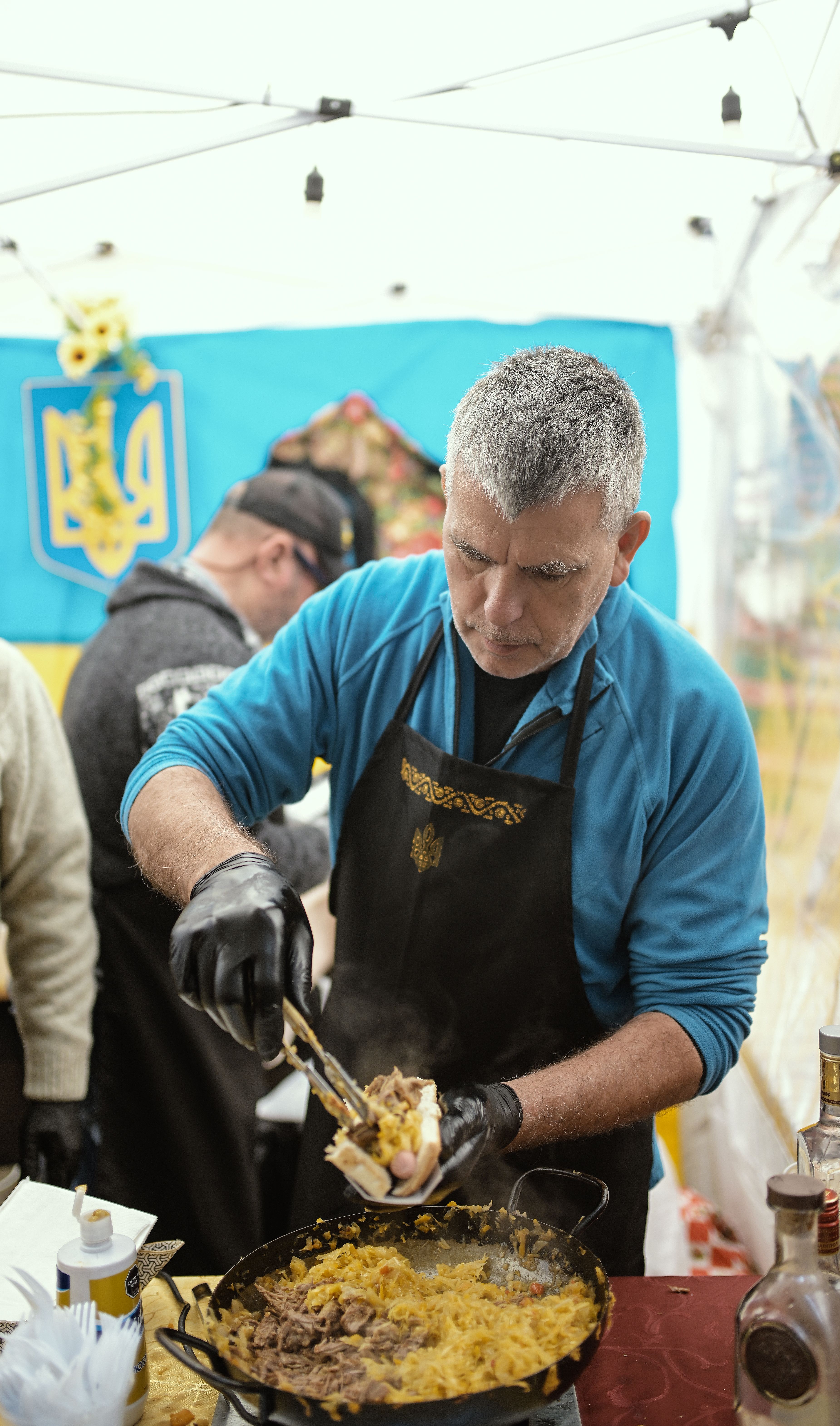 Chef prepares food at an outdoor festival in Buenos Aires, Argentina, showcasing vibrant street food culture.