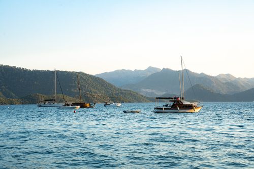 Free Scenic view of sailboats on Marmaris Bay with mountains and sunset sky. Stock Photo