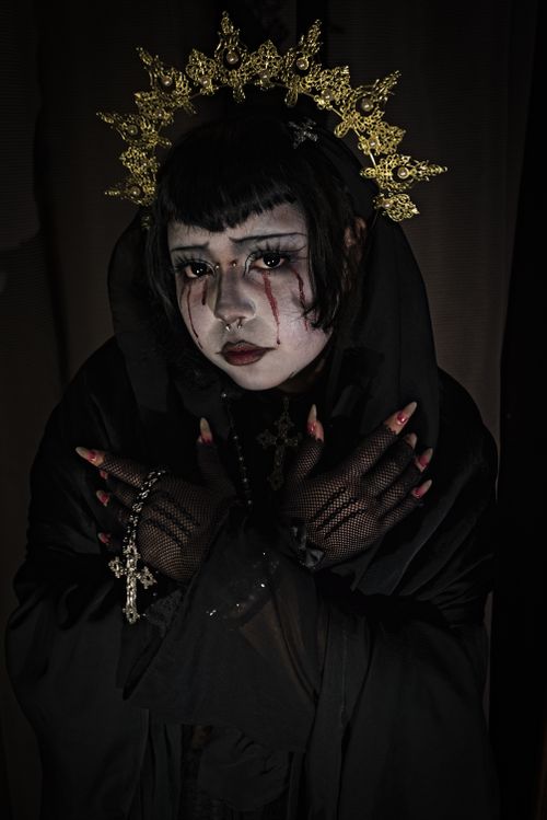 Free A moody portrait of a person in gothic attire with intense makeup and ornate crown. Stock Photo