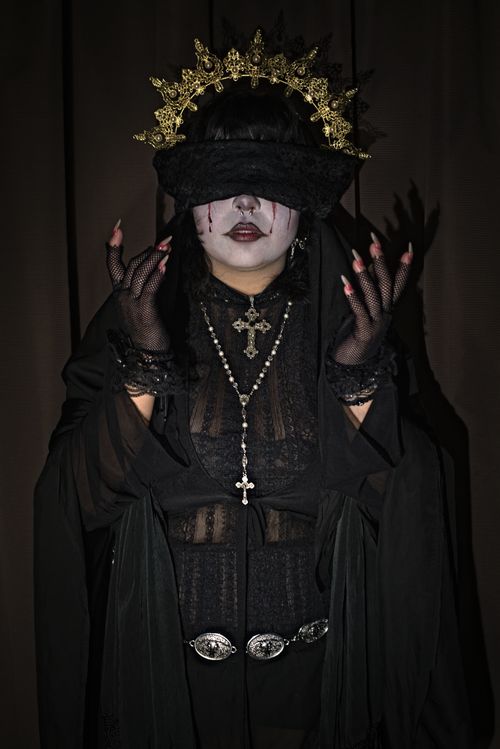 Free Woman in gothic attire wearing a crown and veil with dramatic lighting. Stock Photo