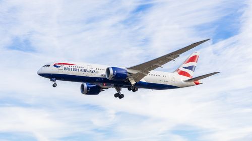 Free A British Airways Boeing 787 Dreamliner flying against a clear blue sky. Stock Photo