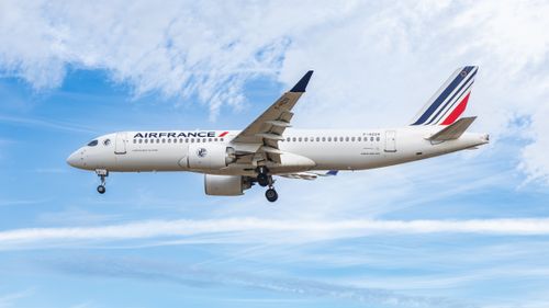Free Air France Airbus A220-300 gracefully flying through a clear blue sky. Stock Photo